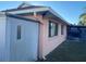 View of house exterior showcasing a light peach color and landscaping at 5105 Garden Vale Ave, Tampa, FL 33624