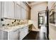 Elegant wet bar with granite countertop and hexagon tile backsplash at 5120 W Longfellow Ave, Tampa, FL 33629