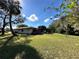 Sunny backyard, featuring a shed and screened patio area at 6823 Bottle Brush Dr, Port Richey, FL 34668