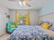 Bedroom featuring a bed, teal armchair, and window with yellow curtains at 9626 Channing Hill Dr, Ruskin, FL 33573