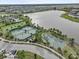 Aerial view of community tennis and basketball courts near a lake at 9626 Channing Hill Dr, Ruskin, FL 33573