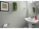 Small bathroom with pedestal sink, mirror, and neutral-colored walls at 10334 Estero Bay Ln, Tampa, FL 33625