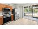 Modern kitchen with stainless steel appliances, wood cabinets, and access to a screened patio at 10334 Estero Bay Ln, Tampa, FL 33625