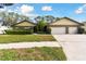 House exterior featuring a three-car garage and lush lawn at 1121 Belladonna Dr, Brandon, FL 33510