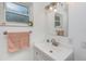 Clean bathroom with a white vanity, updated fixtures, and a window at 1201 Kapok Cir, Clearwater, FL 33759