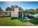 Home exterior showcasing a screened porch and well-maintained lawn at 1201 Kapok Cir, Clearwater, FL 33759