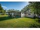 Backyard view of the house, highlighting the screened porch and landscaping at 1201 Kapok Cir, Clearwater, FL 33759