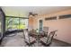 Spacious screened-in porch with hanging chair and dining set at 1201 Kapok Cir, Clearwater, FL 33759