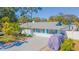 Single-story home with a light blue exterior, palm trees, and a paved driveway, partially covered vehicle at 1204 Cedar Tree Ln, Seffner, FL 33584