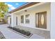 Welcoming front porch featuring an elegant entry door and newly planted shrubs at 12563 Gulliver Rd, Spring Hill, FL 34609