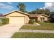 Single-story home with attached garage and well-manicured lawn at 14811 Oak Vine Dr, Lutz, FL 33559