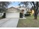 Charming two-story home featuring a well-manicured lawn, mature trees, and an attached two-car garage at 18127 Sandy Pointe Dr, Tampa, FL 33647