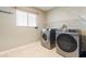 Practical laundry room equipped with modern washer and dryer, with shelving and a window for ventilation at 18127 Sandy Pointe Dr, Tampa, FL 33647