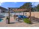 Pergola-covered patio with seating and lush landscaping at 265 Meadow Oak Ln, Tarpon Springs, FL 34689