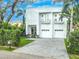 Modern two-story white house with a two-car garage and landscaped front yard at 2711 W Trilby Ave, Tampa, FL 33611