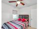 Bedroom with window, ceiling fan, and bed with red pillows at 29 Croom Rd, Brooksville, FL 34601