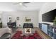 Living room with hardwood floors, modern furniture, ceiling fan, and a large TV at 340 1St N St # I, St Petersburg, FL 33701
