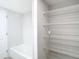 Bathroom with tub and adjacent storage closet with wire shelving at 400 Island Way # 1411, Clearwater Beach, FL 33767