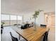 Modern dining area with long wood table and four black chairs, near living room at 400 Island Way # 1411, Clearwater Beach, FL 33767