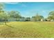 Spacious backyard with grassy area and storage sheds under a clear blue sky at 5201 Pless Rd, Plant City, FL 33565