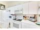 Kitchen equipped with a refrigerator, electric range, microwave, and white cabinetry at 5201 Pless Rd, Plant City, FL 33565