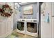 Laundry room with front-loading washer and dryer, storage space, and decorative door at 5201 Pless Rd, Plant City, FL 33565