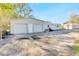 Metal outbuilding with roll-up doors, gravel driveway, and additional storage structures at 5201 Pless Rd, Plant City, FL 33565