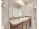 Bathroom with granite countertop, dark brown vanity and a large mirror at 5508 Rainwood Meadows Dr, Apollo Beach, FL 33572