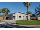 Newly renovated home with a light gray exterior, green door, and well-manicured lawn at 5516 Golden Dr, Tampa, FL 33634