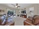 Comfortable living room with leather sofas, large TV, and sliding doors to patio at 6337 Waves End Pl, Apollo Beach, FL 33572