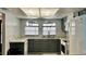 Charming kitchen featuring gray cabinets, white appliances, marble countertops, arched windows and wooden floors at 9107 Lingrove Rd, Weeki Wachee, FL 34613