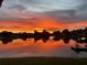 Tranquil lake view featuring a vibrant sunset reflecting on the water at 9107 Lingrove Rd, Weeki Wachee, FL 34613