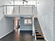 Bright living room with stairs leading to the loft space, ceiling fan, and view into the kitchen area at 9107 Lingrove Rd, Weeki Wachee, FL 34613