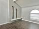 Open living room featuring wood-look flooring, a brick fireplace, and an arched window at 9107 Lingrove Rd, Weeki Wachee, FL 34613