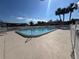 Community swimming pool surrounded by a white fence and palm trees at 9107 Lingrove Rd, Weeki Wachee, FL 34613