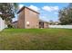Backyard with grassy lawn and a view of the home's exterior at 11240 Ragsdale Ct, New Port Richey, FL 34654