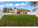 Large backyard with grassy area, privacy fence, and home view at 11240 Ragsdale Ct, New Port Richey, FL 34654