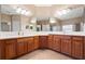 Double vanity bathroom with wood cabinets and a large mirror at 11240 Ragsdale Ct, New Port Richey, FL 34654