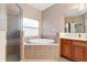 Bathroom with a soaking tub, shower, and wood cabinets at 11240 Ragsdale Ct, New Port Richey, FL 34654