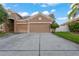Two-car garage with a large driveway and green grass at 11240 Ragsdale Ct, New Port Richey, FL 34654