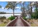 Serene wooden walkway leads to a peaceful dock overlooking the lake at 11240 Ragsdale Ct, New Port Richey, FL 34654