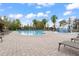 Community pool with lounge chairs, a splash pad, and palm trees, perfect for summer relaxation and recreation at 11240 Ragsdale Ct, New Port Richey, FL 34654