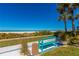 Tranquil bench view overlooking the beach, with palm trees, landscaping, and blue skies at 1390 Gulf Blvd # Ph-1, Clearwater Beach, FL 33767