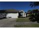 House exterior featuring a two-car garage and well-manicured landscaping at 19409 Weymouth Dr, Land O Lakes, FL 34638