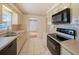 Kitchen with light cabinets, black appliances, and tile floor at 2921 Forestwood Dr, Seffner, FL 33584