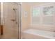 Bathroom with shower, bathtub, and window with plantation shutters at 29508 Chapel Park Dr, Wesley Chapel, FL 33543