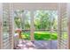 Relaxing screened porch with brick flooring, wicker chair, and view of backyard at 29508 Chapel Park Dr, Wesley Chapel, FL 33543