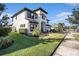 Two-story house with white exterior, dark brown accents, and lush landscaping at 32298 Talimena Loop, Wesley Chapel, FL 33543