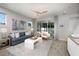 Bright living room with gray sofa, sliding doors to lanai, and wood-look tile floors at 3234 Sunrise Spring Pl, Brandon, FL 33511