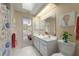 Bathroom with double vanity, decorative seashells, and a skylight, with a bedroom view at 3401 Avenida Madera # B, Bradenton, FL 34210